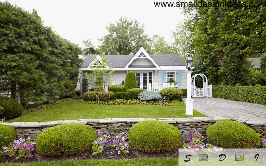 Neat English style exterior of the house with a bright houses adjoining garden bed and fancy blue shutters