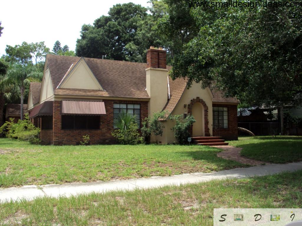 Modest American house in English style with small porch and stone chimney