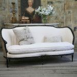Classic vintage furniture and decorations with vase, candlestick and picture as the background of the cozy white textile couch