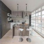 Kitchen with a lot of metal details and with grey and steel decoration, wooden glass grid to the balcony at the Loft kitchen