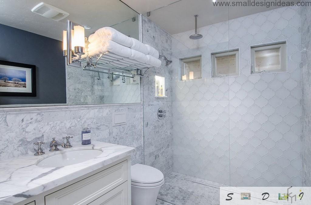 Ideally white bathroom with textured tile walls, terry clothed towels and a sink