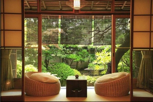 Veranda of the country house in the Japanese style with rattan puffs and low table