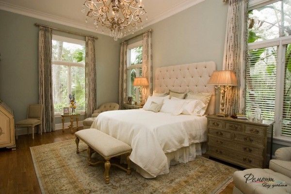 bedside table and the chic big bed in the royal interior with huge wrought chandelier