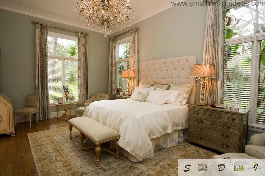 bedside table and the chic big bed in the royal interior with huge wrought chandelier