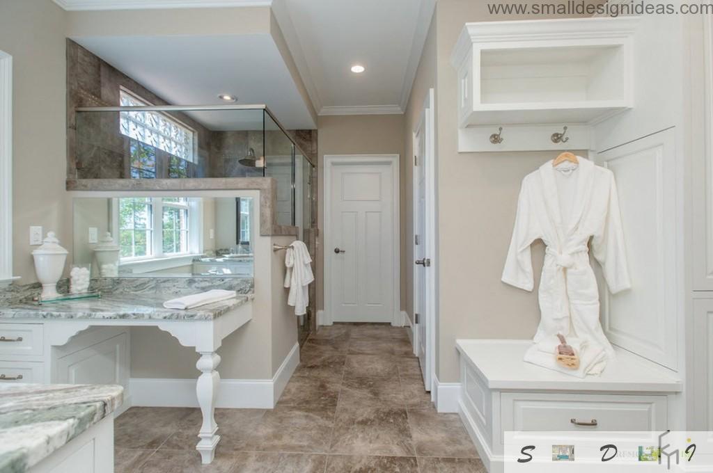 Terry bathrobe and a sink with marble surface next to glass shower cabin creates a really bohemian atmosphere in the classic designed bathroom