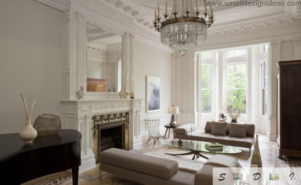 Crystal royal chandelier and the fireplace with big mirror above in the classic living room interior