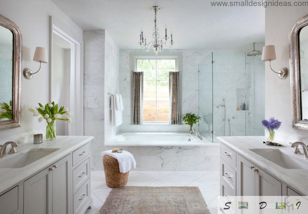 Bathroom with rwo sinks at different walls and a bathroom in center with marble trim