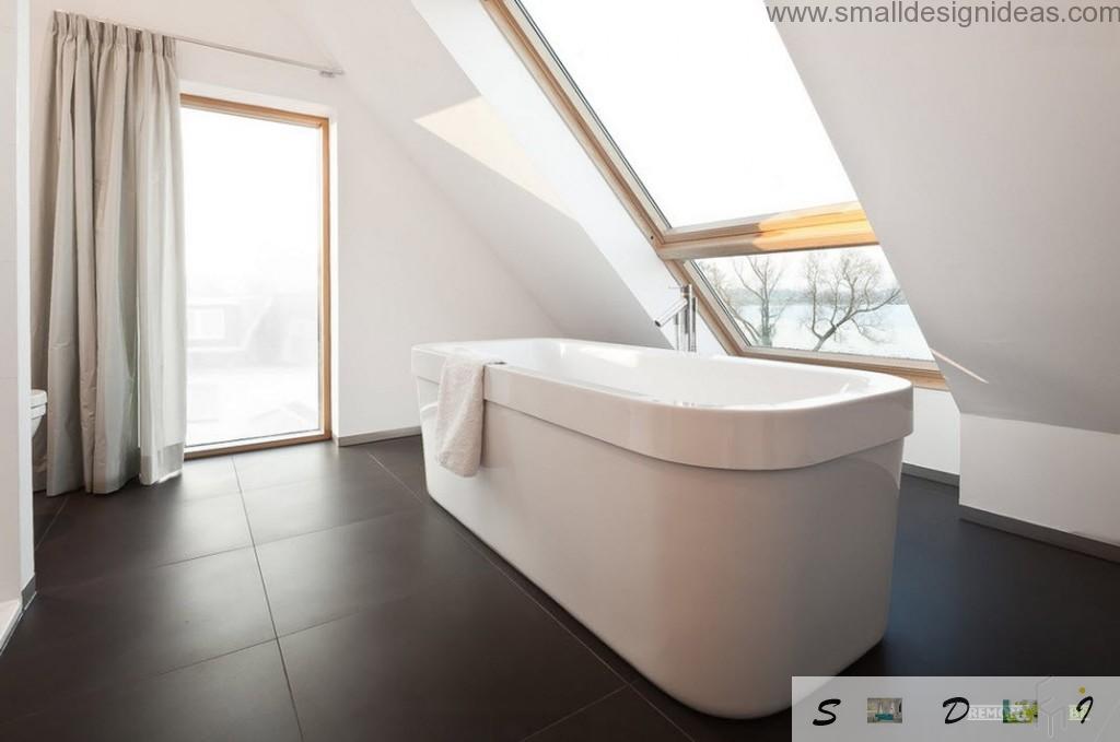 Oval austere bathroom in the contrasting black and white interior of the bathroom with the sloped ceiling and the top window