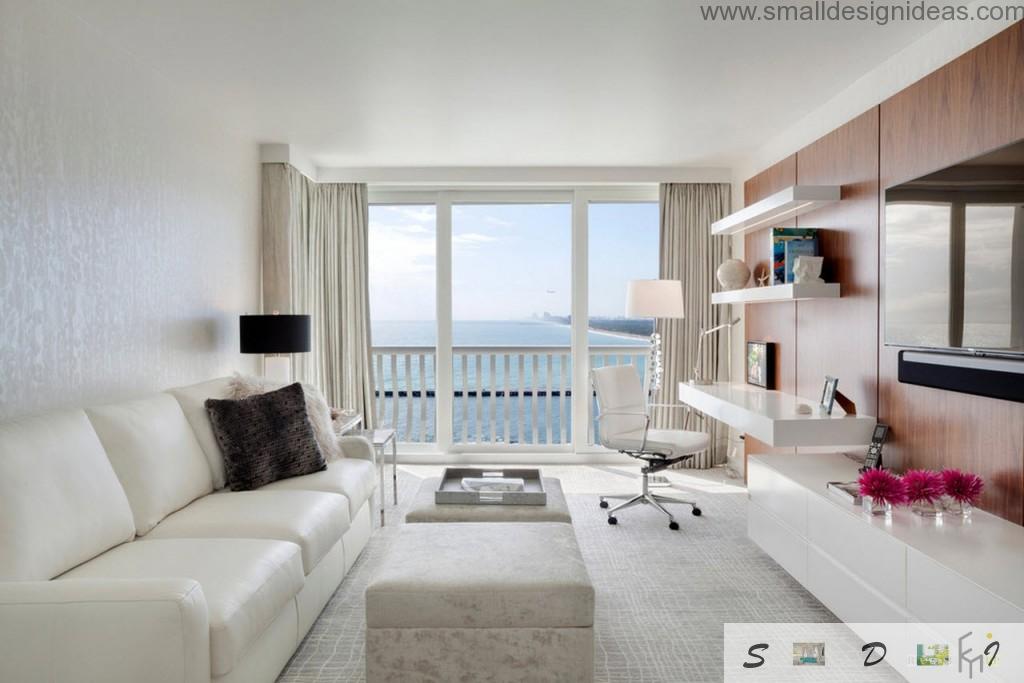 Panoramic window in the creamy colors decorated living room if the seaside house