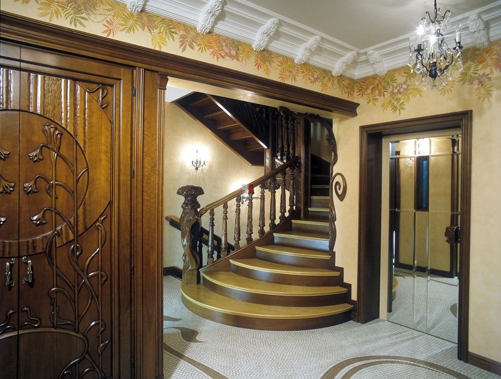 Nice pastel colors in the hall of the countryside house with the stairs trimmed with wooden elements