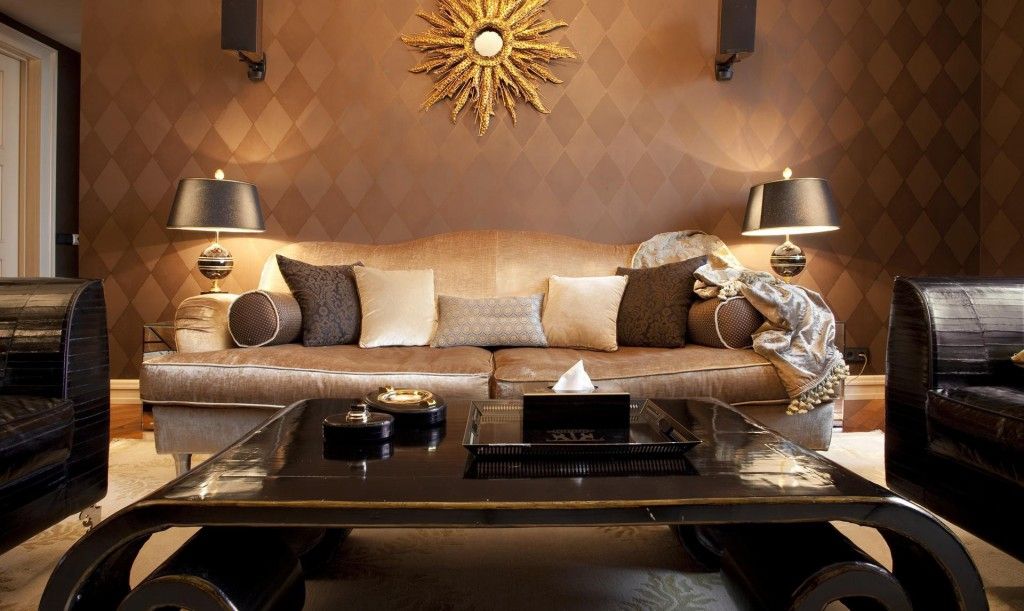 Dark creamy tones in the decoration of the Art Deco living room with a lot of cushions on the couch