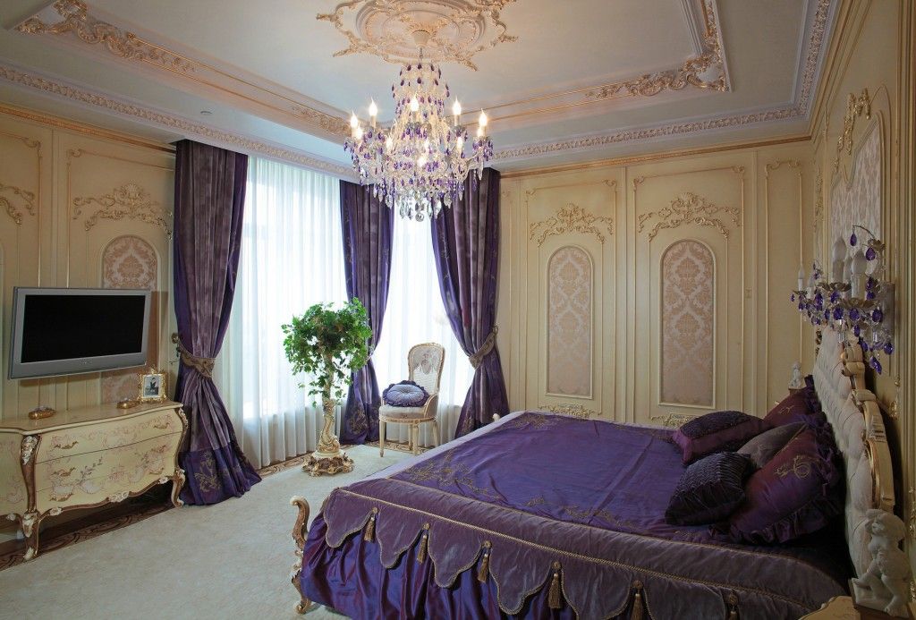 Baroque purple colored bedroom with gilded ceiling stucco and crystal chandelier