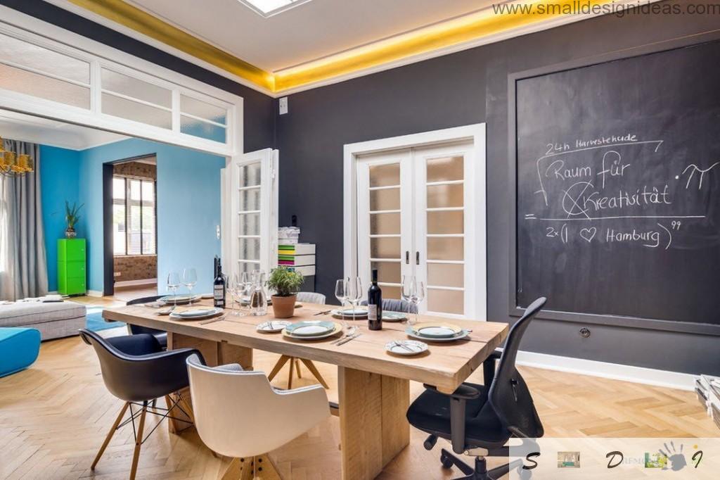 Dining room in the loft German apartment with unusual dark painting of the wall