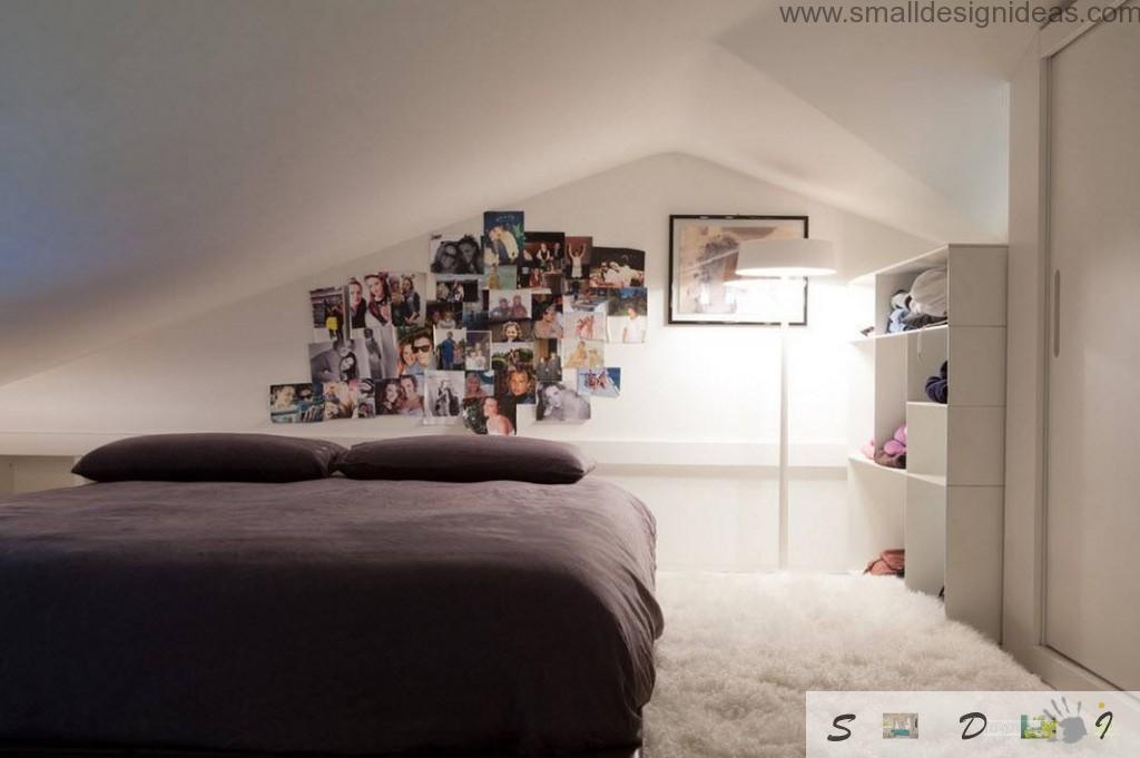 Low-key bedroom with dark bed and photocollection on the white wall