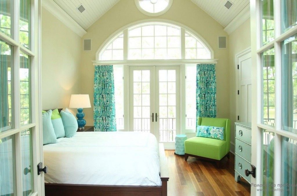 Modern looking bedroom with wooden floor and turquoise curtians