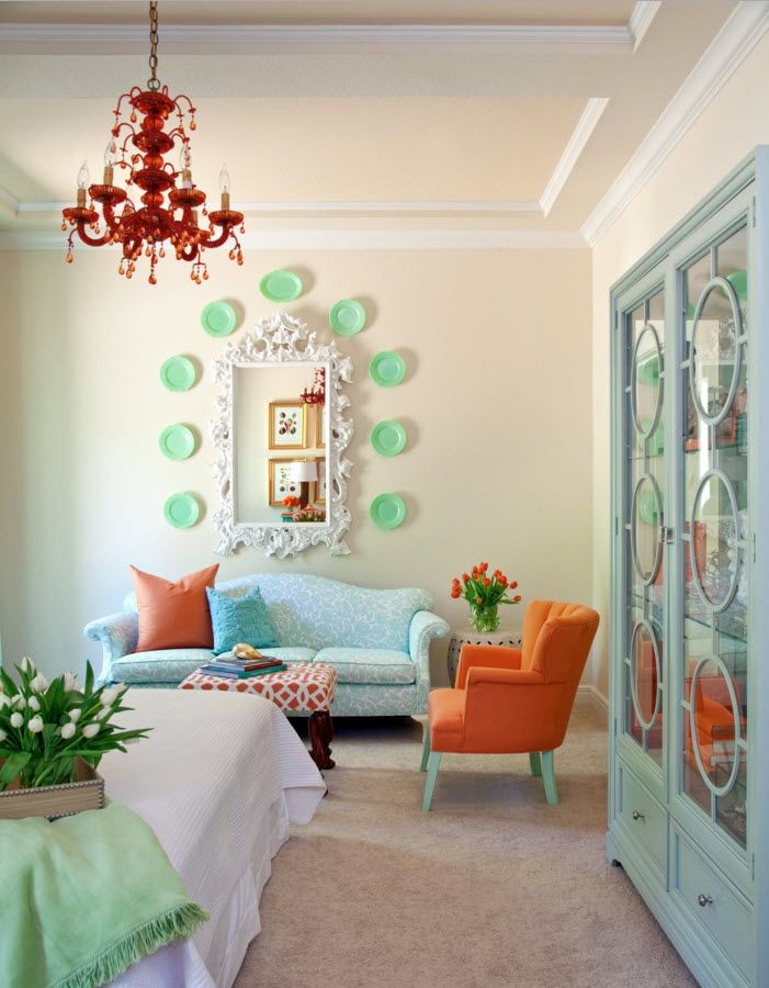 Turquoise decorative plates in the Shabby chic interior with orange armchairs