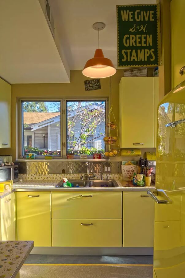 Metal Backsplash as Stylish Design Idea for Kitchen Interior. Warm yellow interior and cold steel contrast