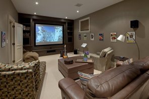Home Theater as Addition to Large Modern Interior. Chic dark leather couch and leather coated coffe table in the center of the area