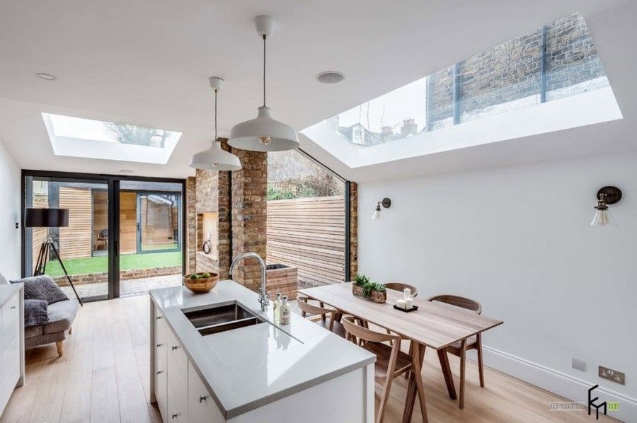 Modern English Country Style Interior Design Example. Kitchen island and the dining zone with panoramic skylight