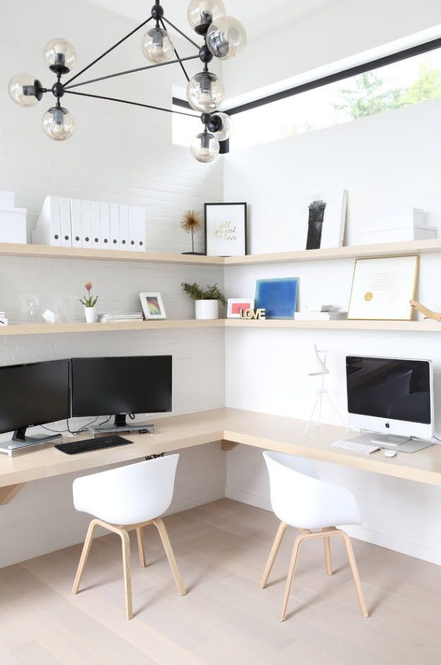 Angle of the room with light wooden shelves and two working places