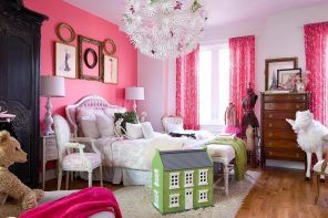 Kids' room with accent pink wall decorated with picture frames
