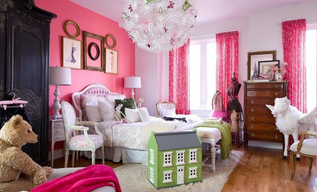 Kids' room with accent pink wall decorated with picture frames