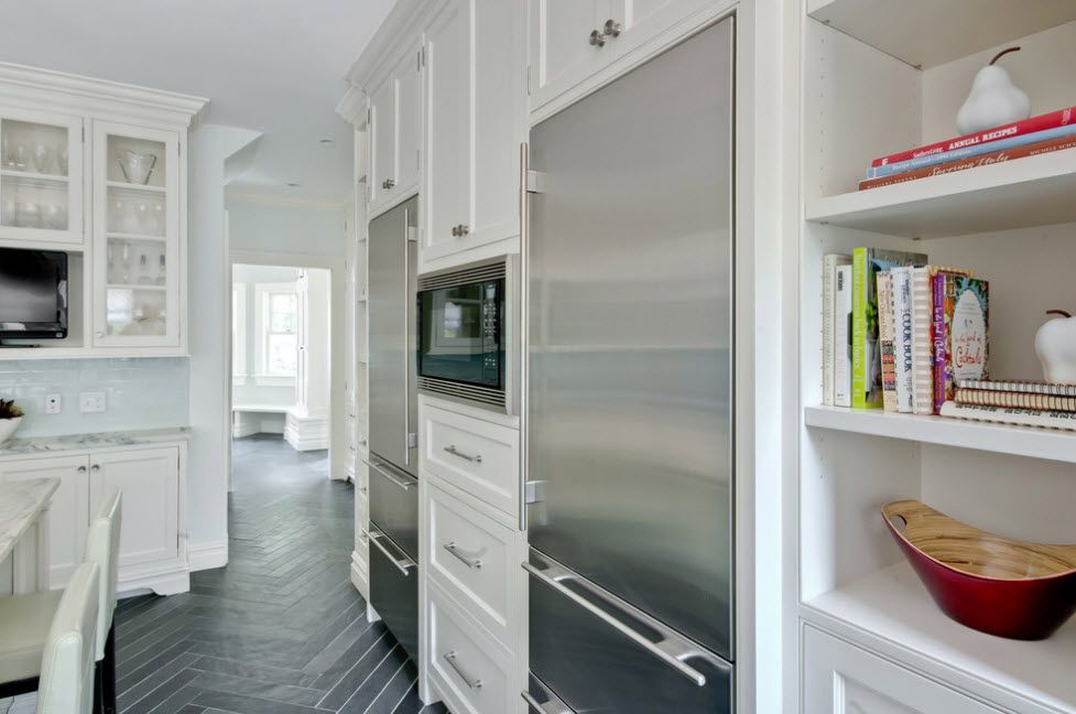 Refrigerator in Modern Kitchen Interior Design. White Classic furnture facades with stucco imitation and steel surface of the fridge