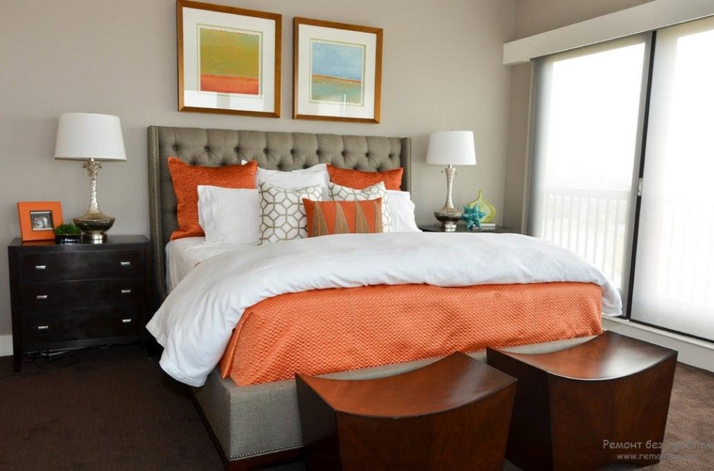 Large bed with silver quilted headboard and orange touch in decoration