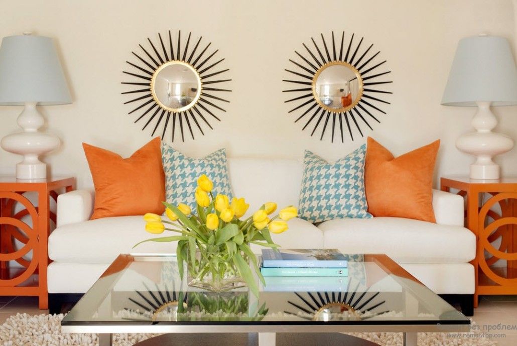 Sunburst mirrors above the sofa decorated with the colorful pillows