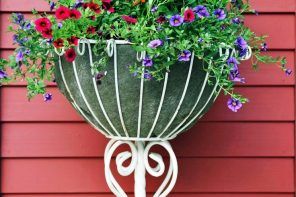 White forged bed stand hanging at the house' facade