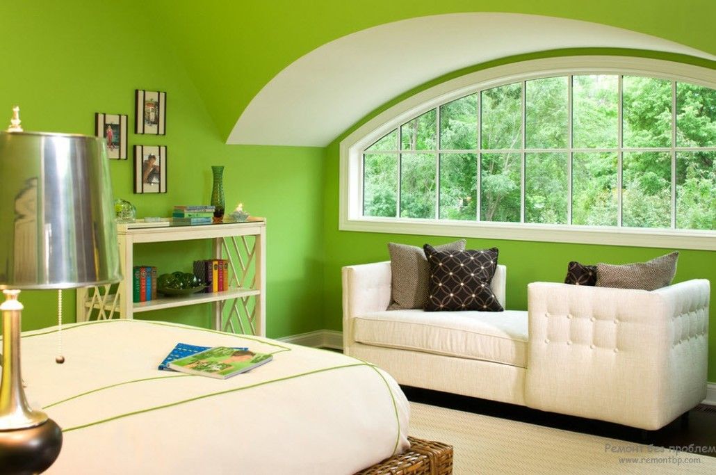 Green painted attic premises of the bedroom with white upholstered furniture