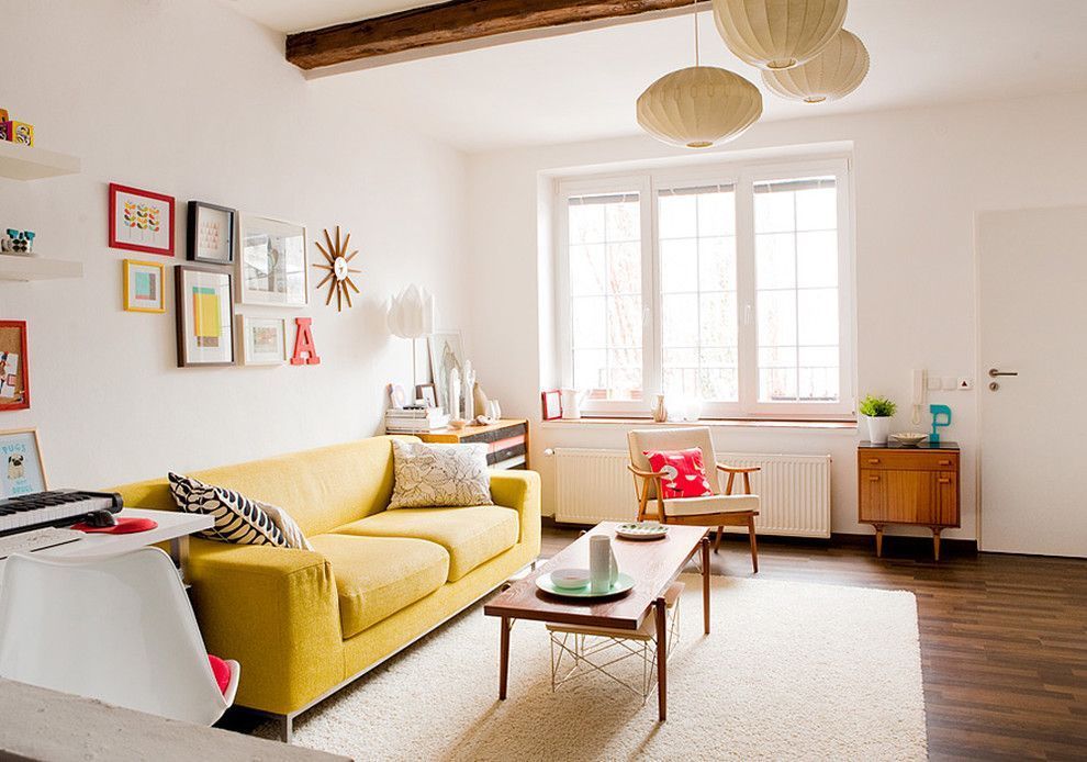 Light successful and cozy room with open ceiling beam and yellow sofa