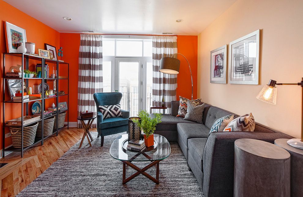 Orange curtians and accent wall in addition to unusual framed armchair make interior flashy