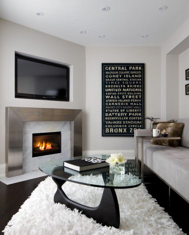 White matte surfaces of the walls and artificial fireplace for the modern styled minimalistic living room