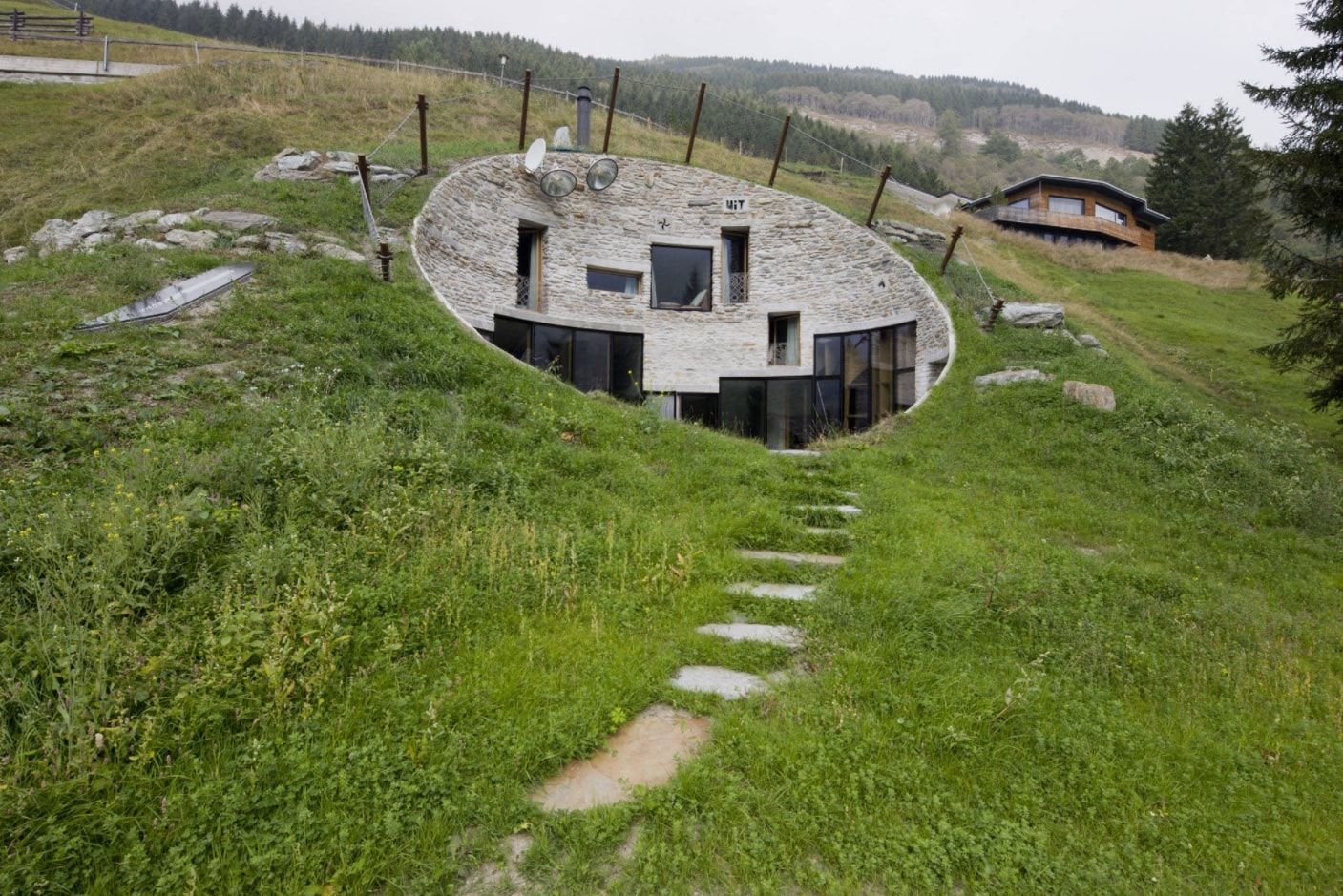 House Built Into Hill or Underground Houses. Unusual UFO alike stone decorated circle exterior