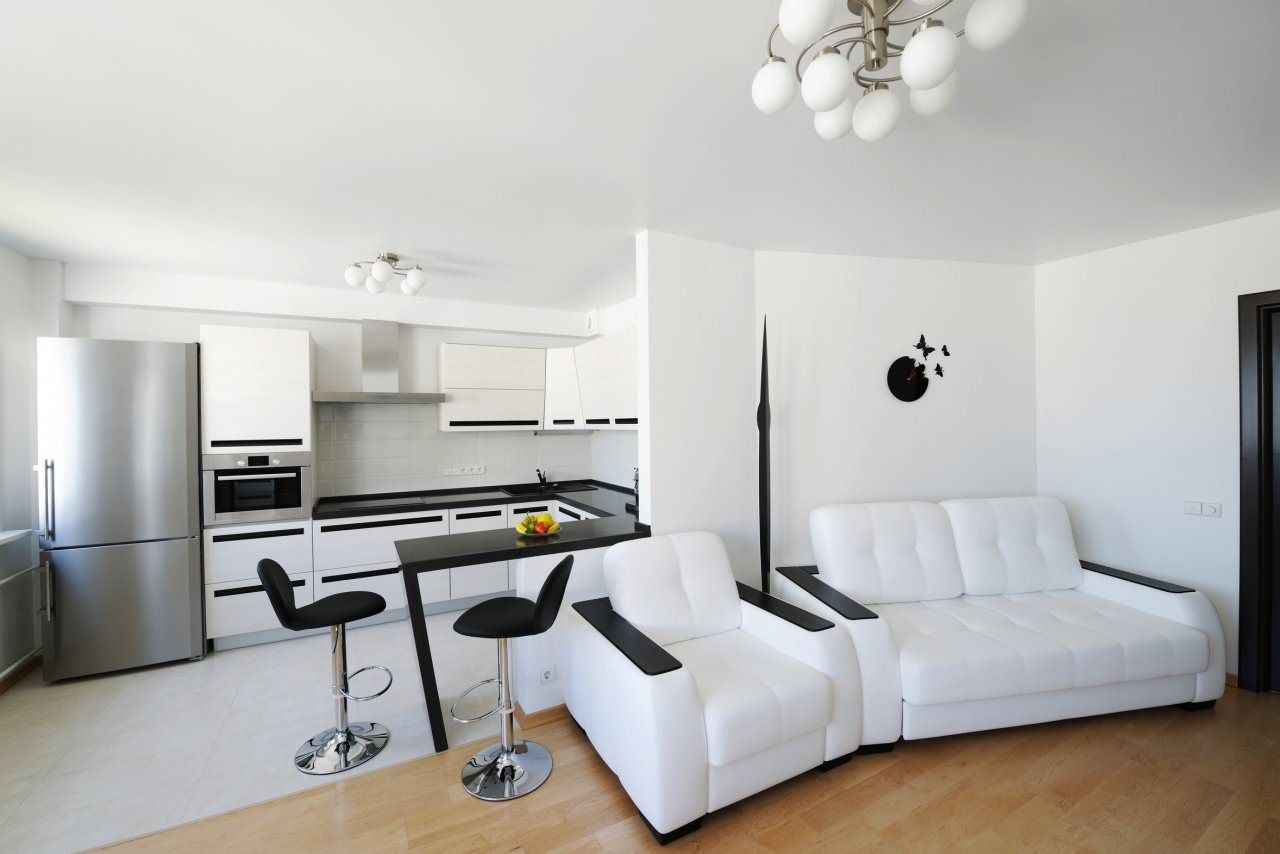 Unusual hi-tech decor in contrasting black and white color scheme with improvised bar counter introducing dining zone