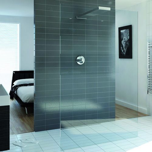 Modern minimalistic shower cabin limited with glass partitions right in the bedroom