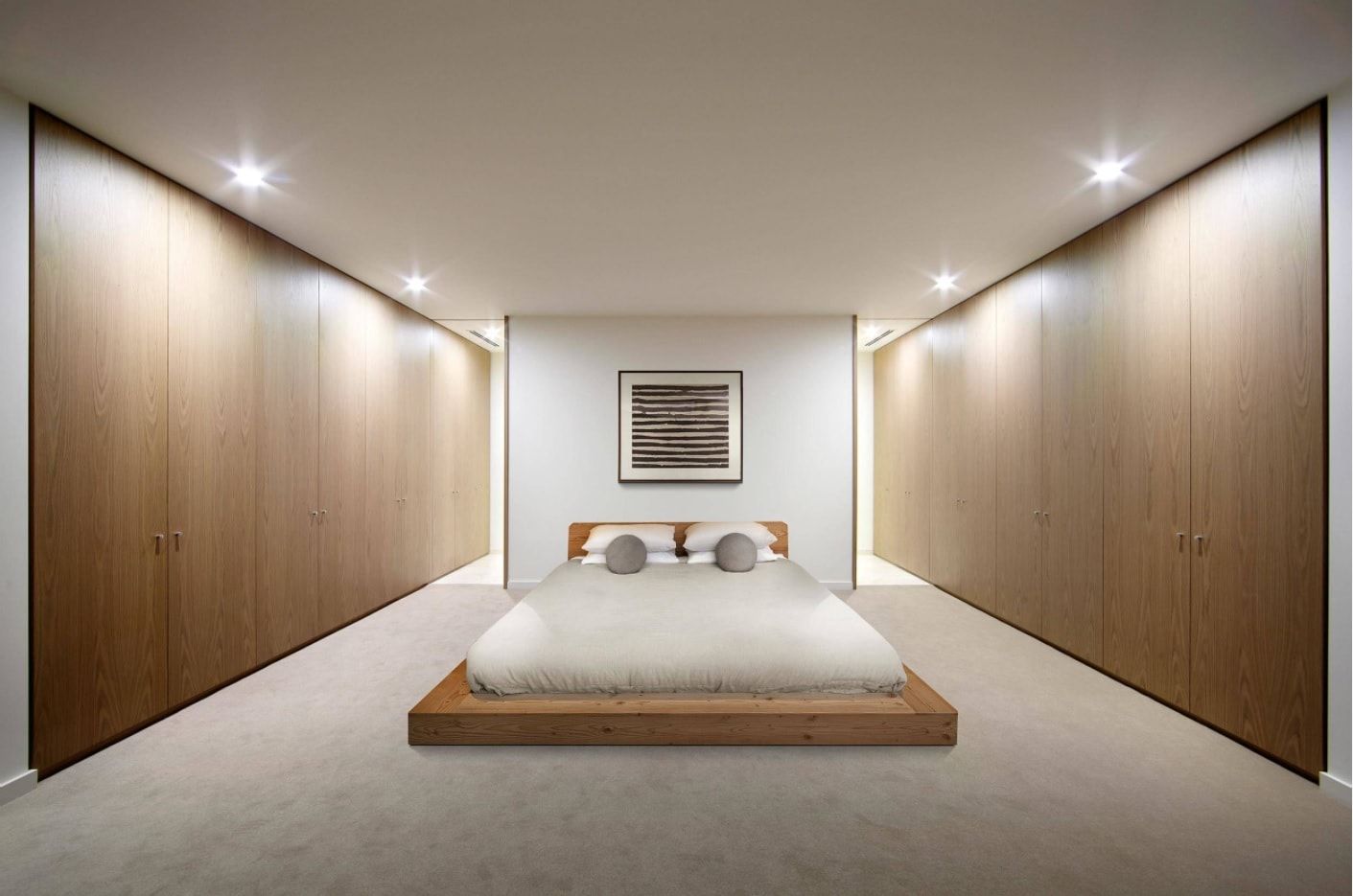 Unusual usage of mirrors to create the sensation of long room in the minimalistic bedroom