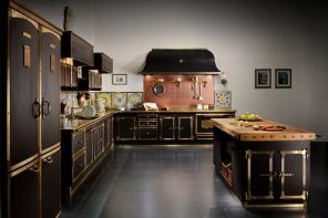 Dark kitchen design with golden fittings and ornament on facades