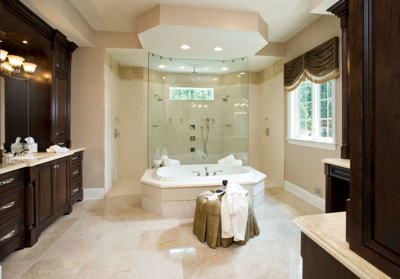 Stone trimmed monolith bathroom with shower zone behind glass separated bathtub