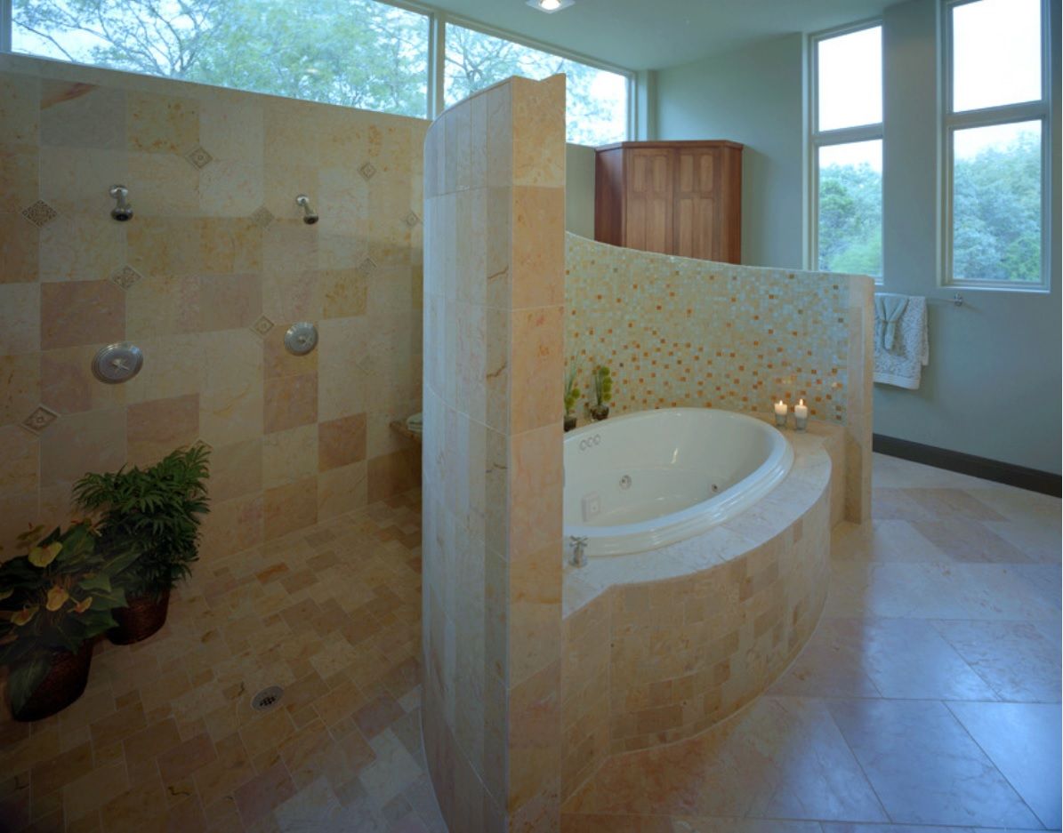 Back wall located shower zone with the wall rounded separated bathtub in front of it