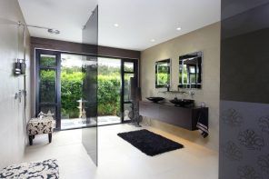 Unique white decorated ultramodern bathroom interior with spectacular idea of black glass partitions