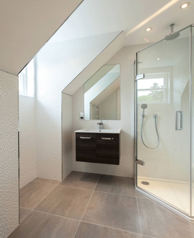 Loft vaults or walls in the hi-tech bathroom with glass partitioned shower zone
