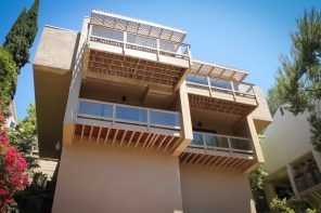 System of wooden balconies at the facade of the sandy colored house