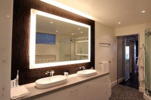 Grand wooden framed mirror in the modern decorated bathroom
