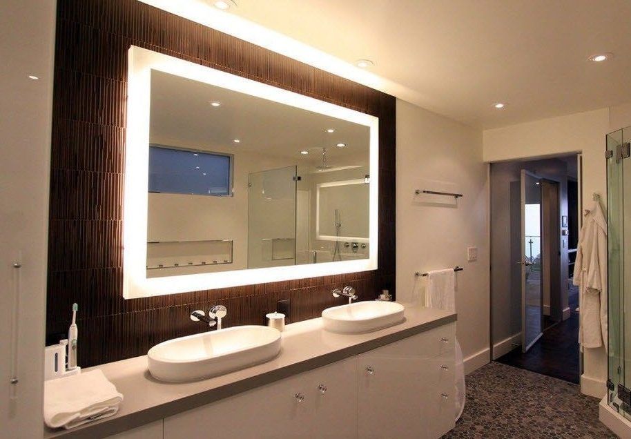 Grand wooden framed mirror in the modern decorated bathroom