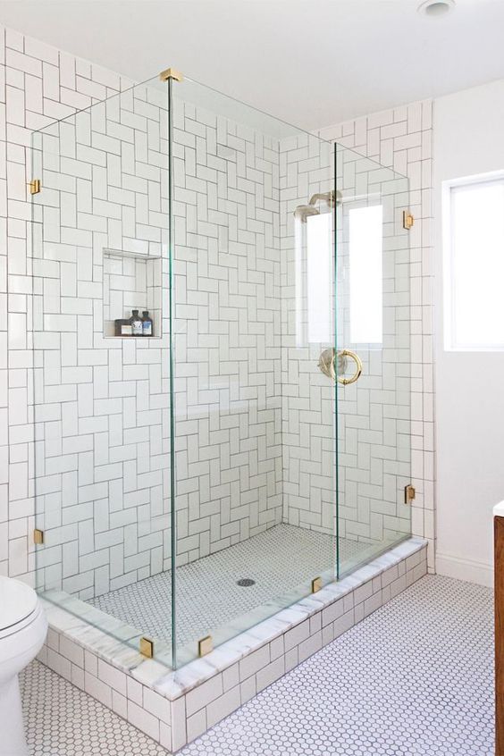Classic chic in the bathroom with glass shower cabin and golden tap