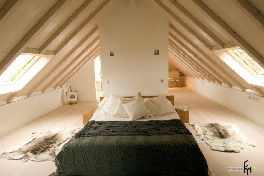 Open wooden beams in light decorated casual interior with large bed