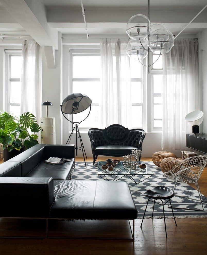 Black angular leather upholstered sofa and royal ottoman for original designed living room