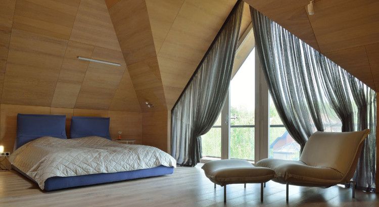 Attic bedroom with matress-based bed and large semi-translucent sheets of the curtains
